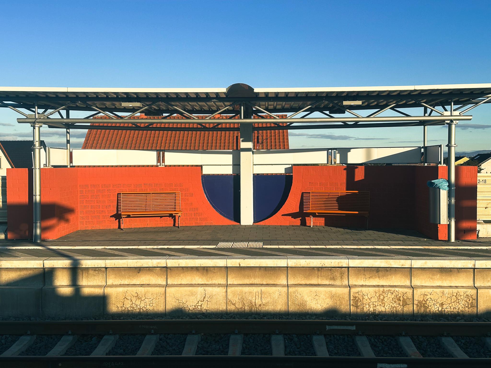 Bahnsteig mit neuen Wandgestaltungen und Sitzbänken.