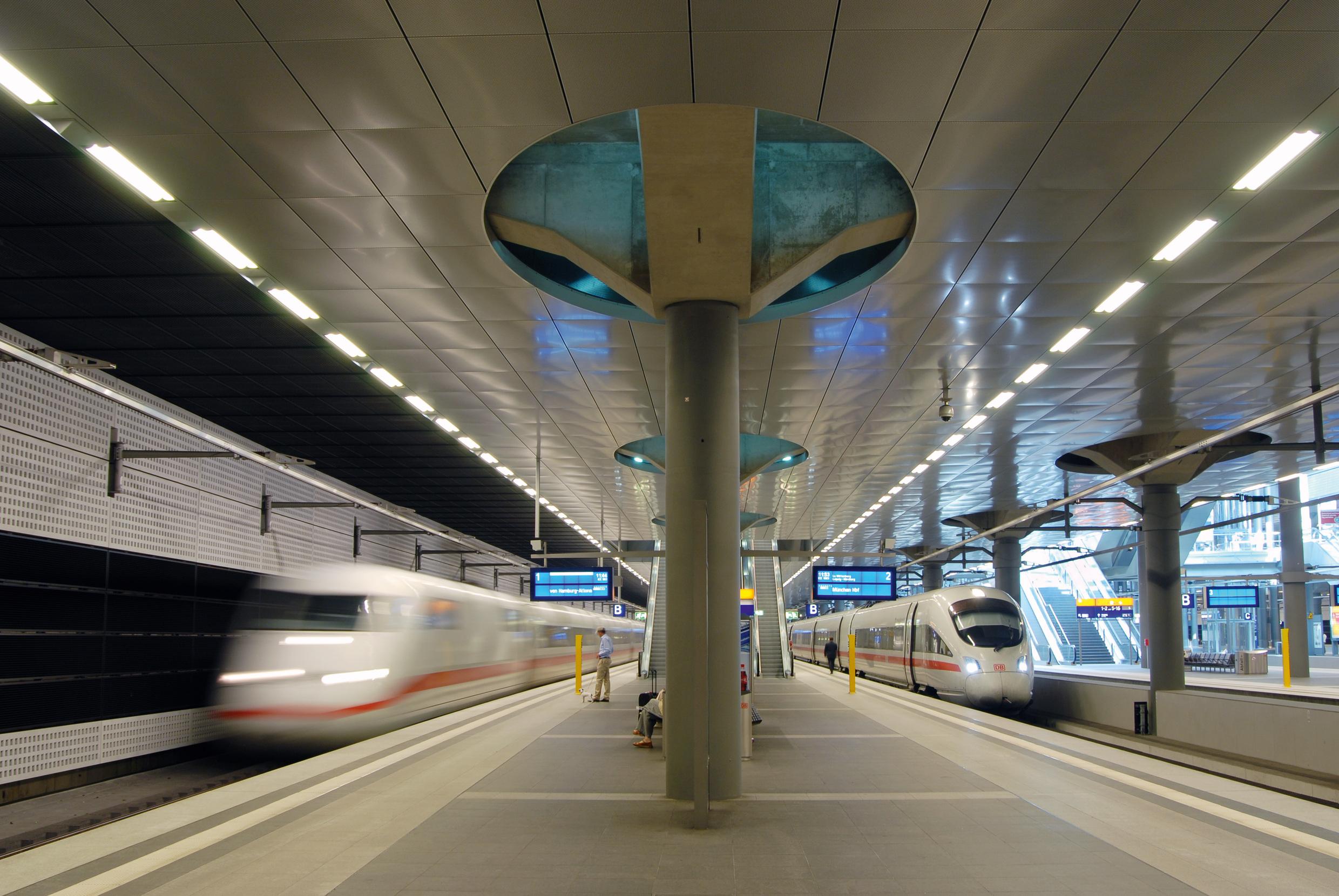 A view of the underground platforms at Berlin Central Station in the East regional area with a stationary and departing ICE train.
