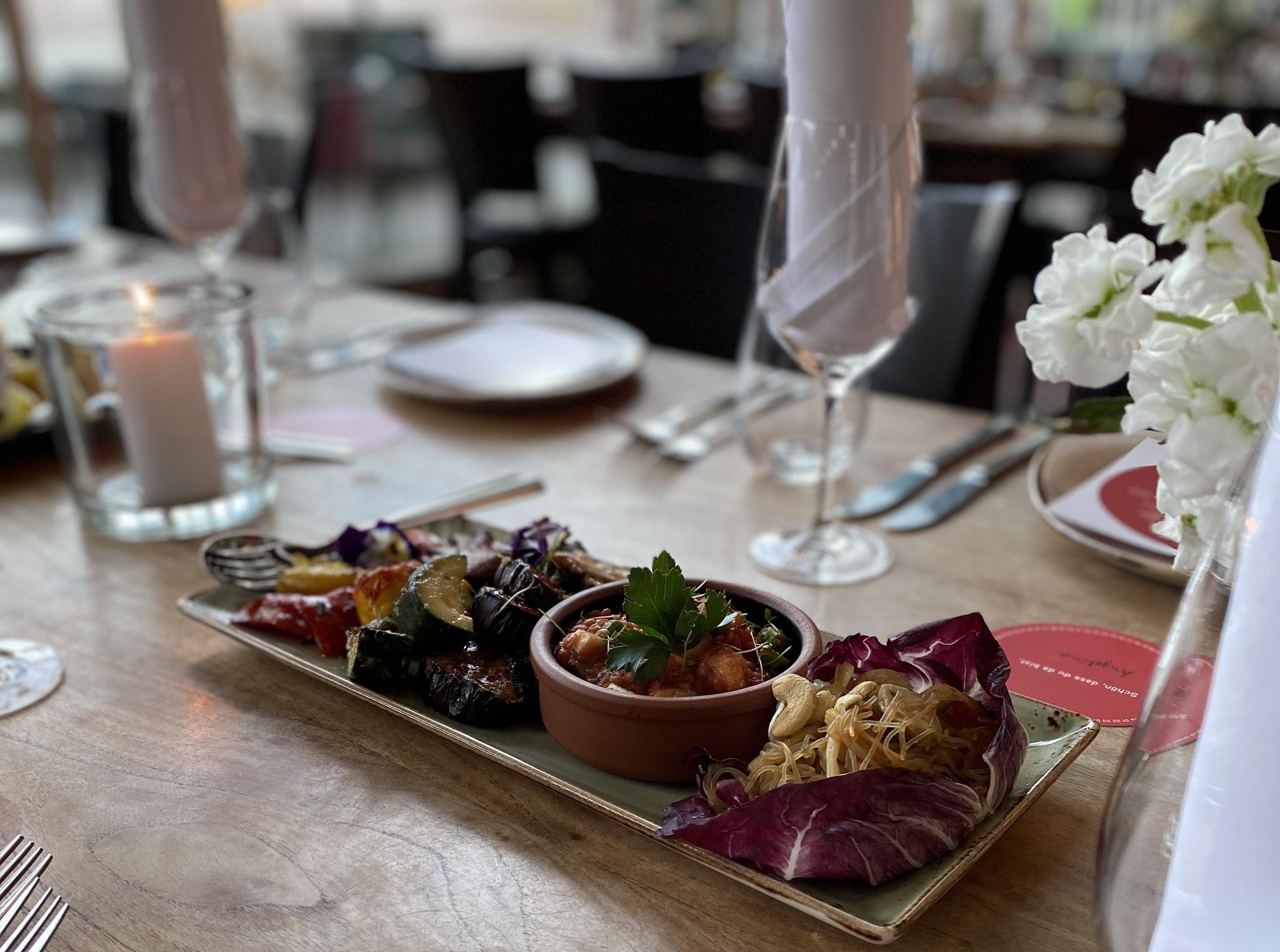 Gedeckter Tisch mit Vorspeisen-Platte in der Mitte.