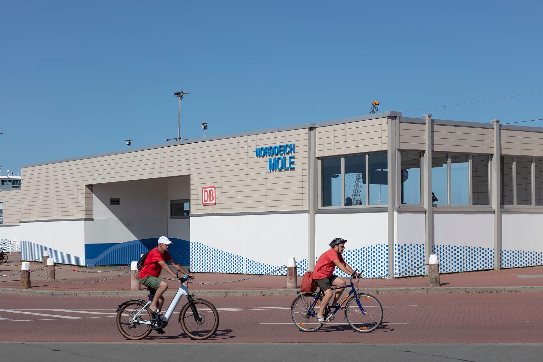 Zwei Fahrradfahrer vor dem Bahnhof Norddeich-Mole