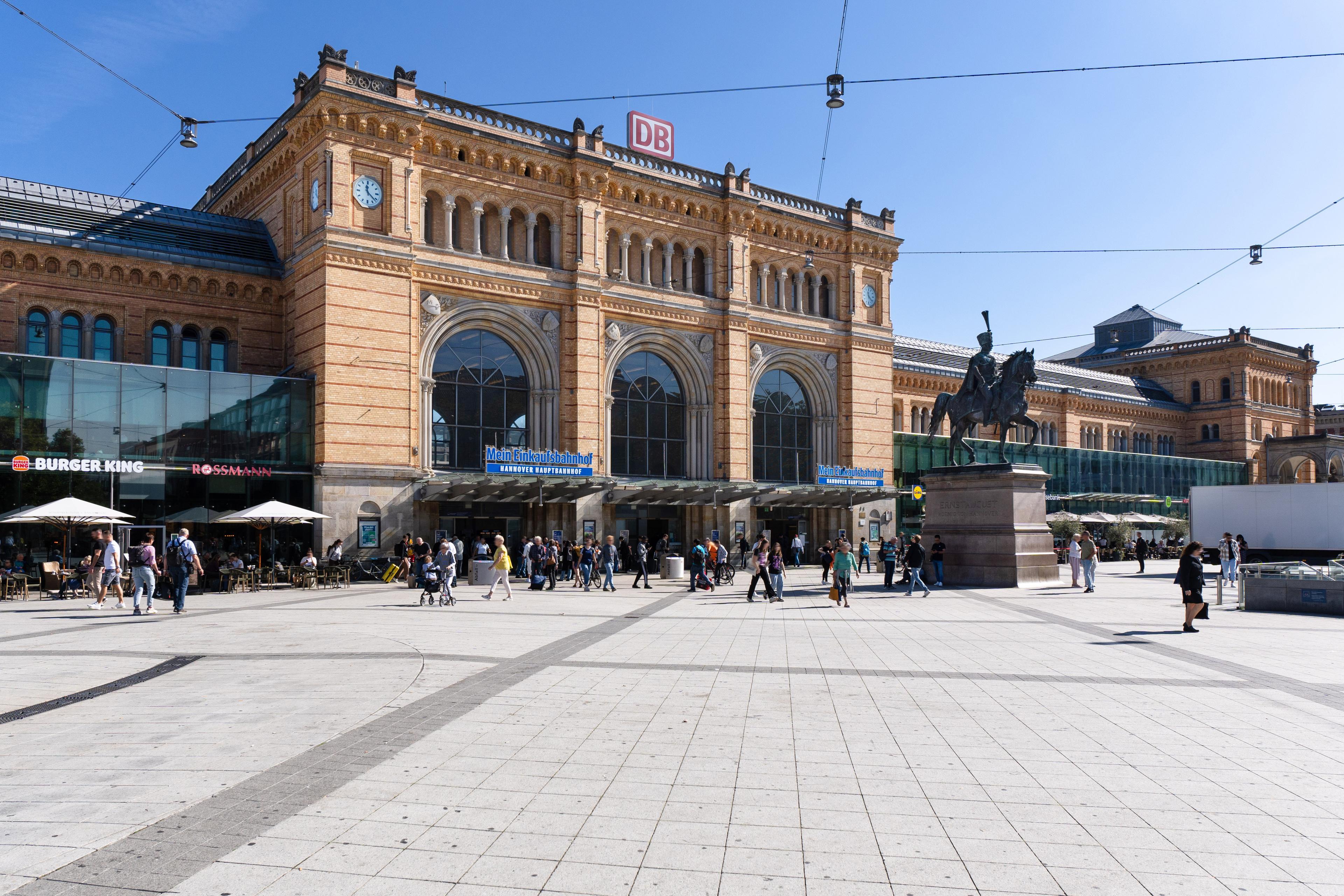 Das Empfangsgebäude des Hauptbahnhofs Hannover mit Menschen im Vordergrund. 