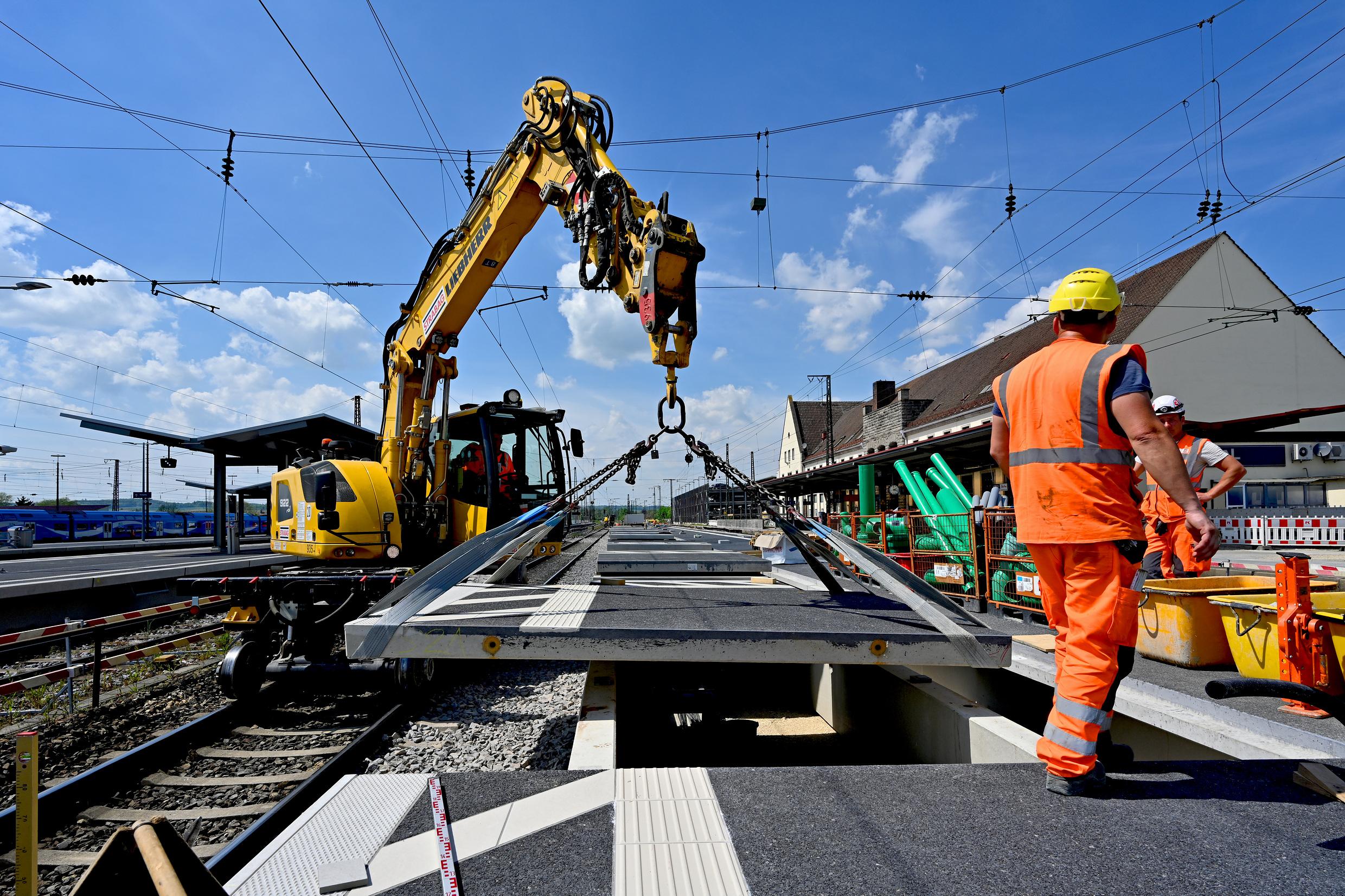 Bauarbeiter errichten einen neuen Bahnsteig.