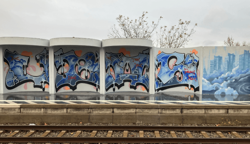 Lärmschutzwand und Wetterschutzbauten am Bahnhof Mannheim-Neckarstadt nach Neugestaltung durch künstlerische Graffiti.