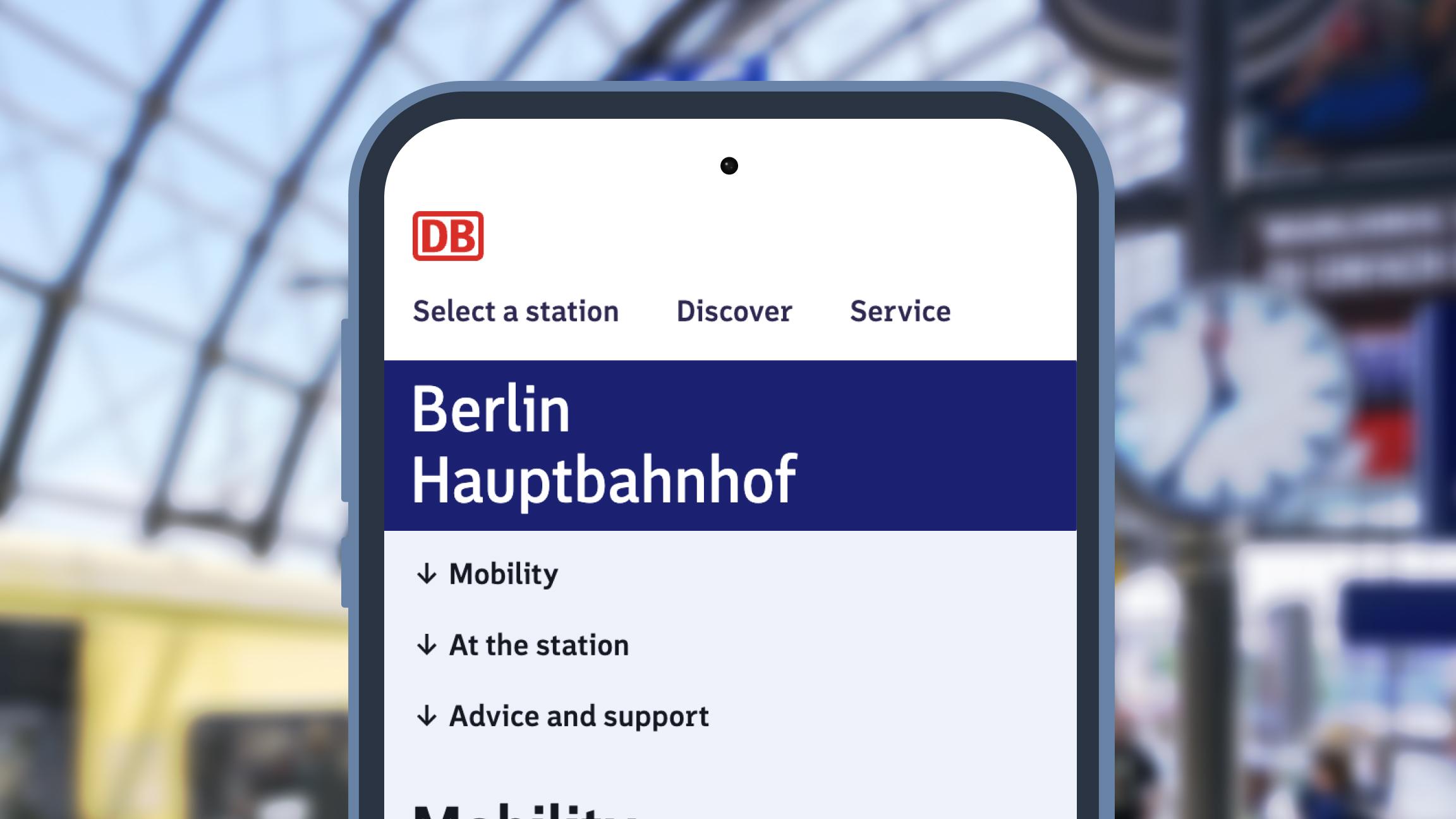 Against the background of a platform with a stopping S-Bahn train, a smartphone is shown with the Berlin Hauptbahnhof station side open.