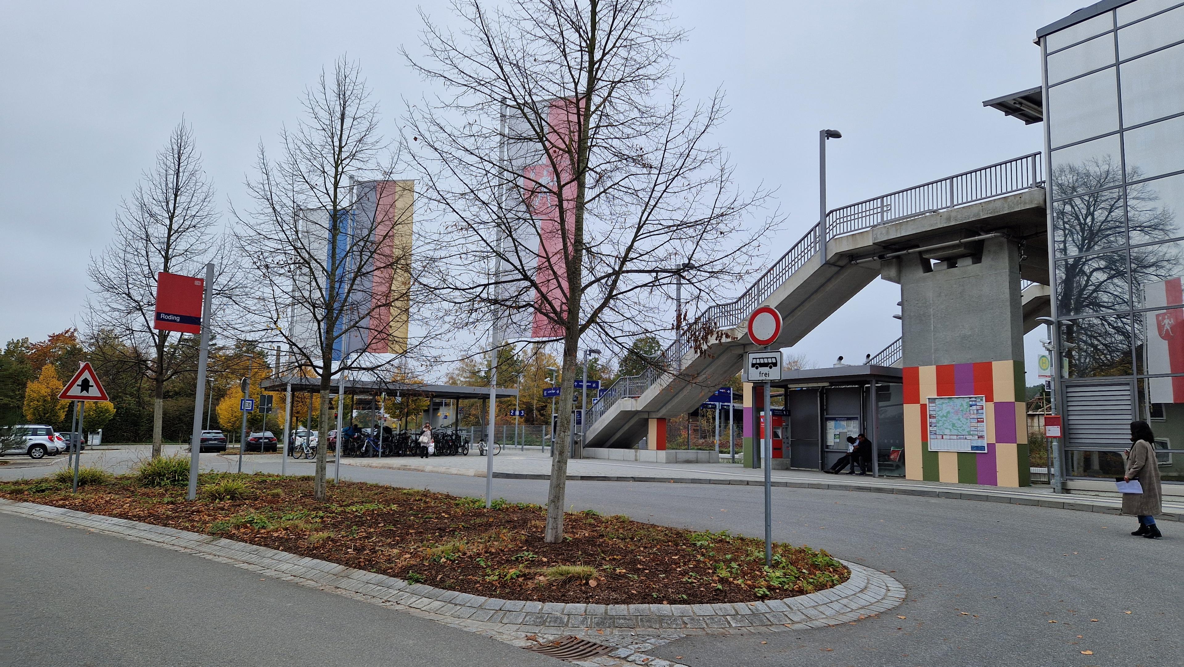 Blick auf den Bahnhofsvorplatz. Zu sehen sind tragende Betonpfeiler mit bunten Akzenten nach der gestalterischen Modernisierung.