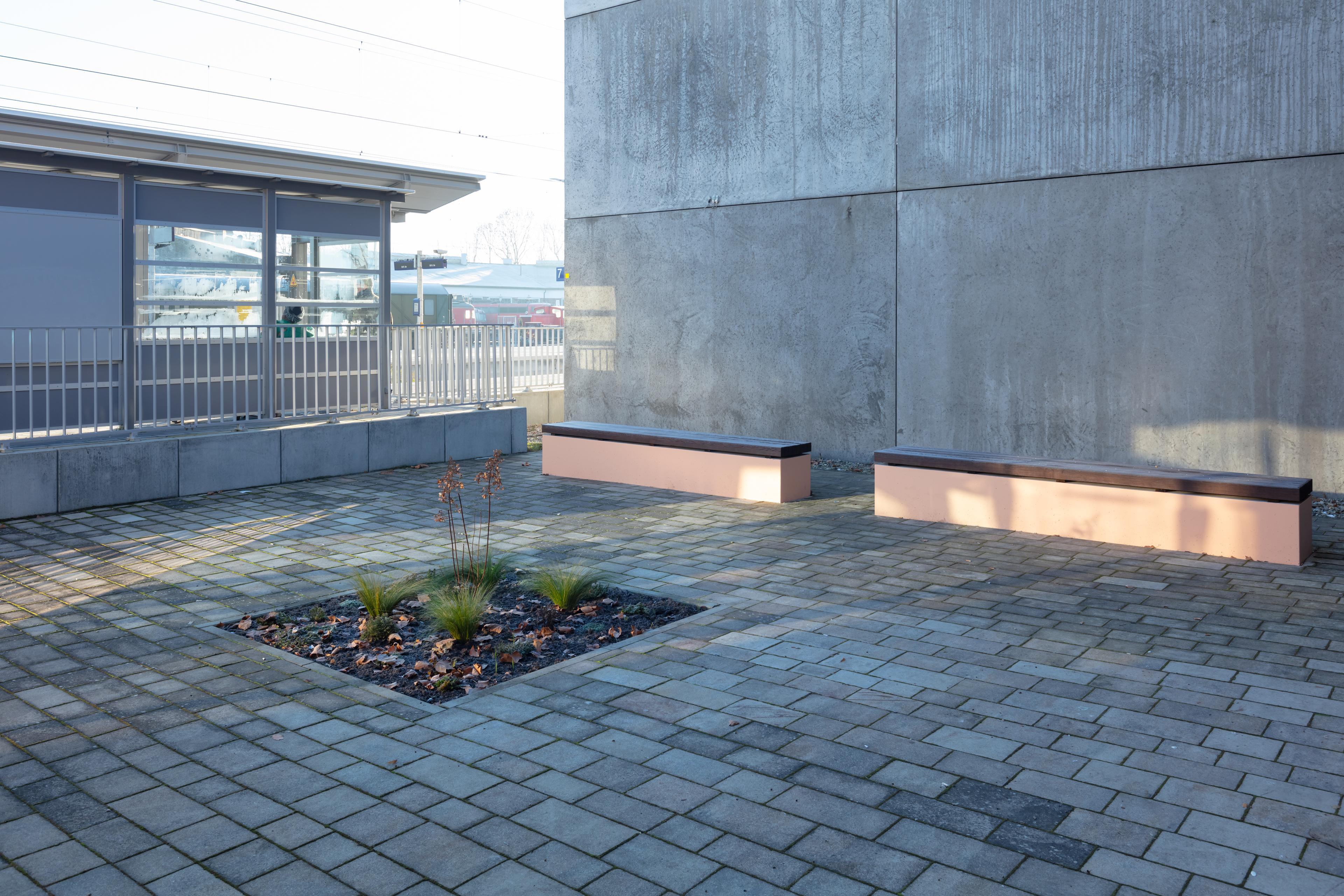 Neue Sitzgelegenheiten am Bahnhof mit Grünfläche.