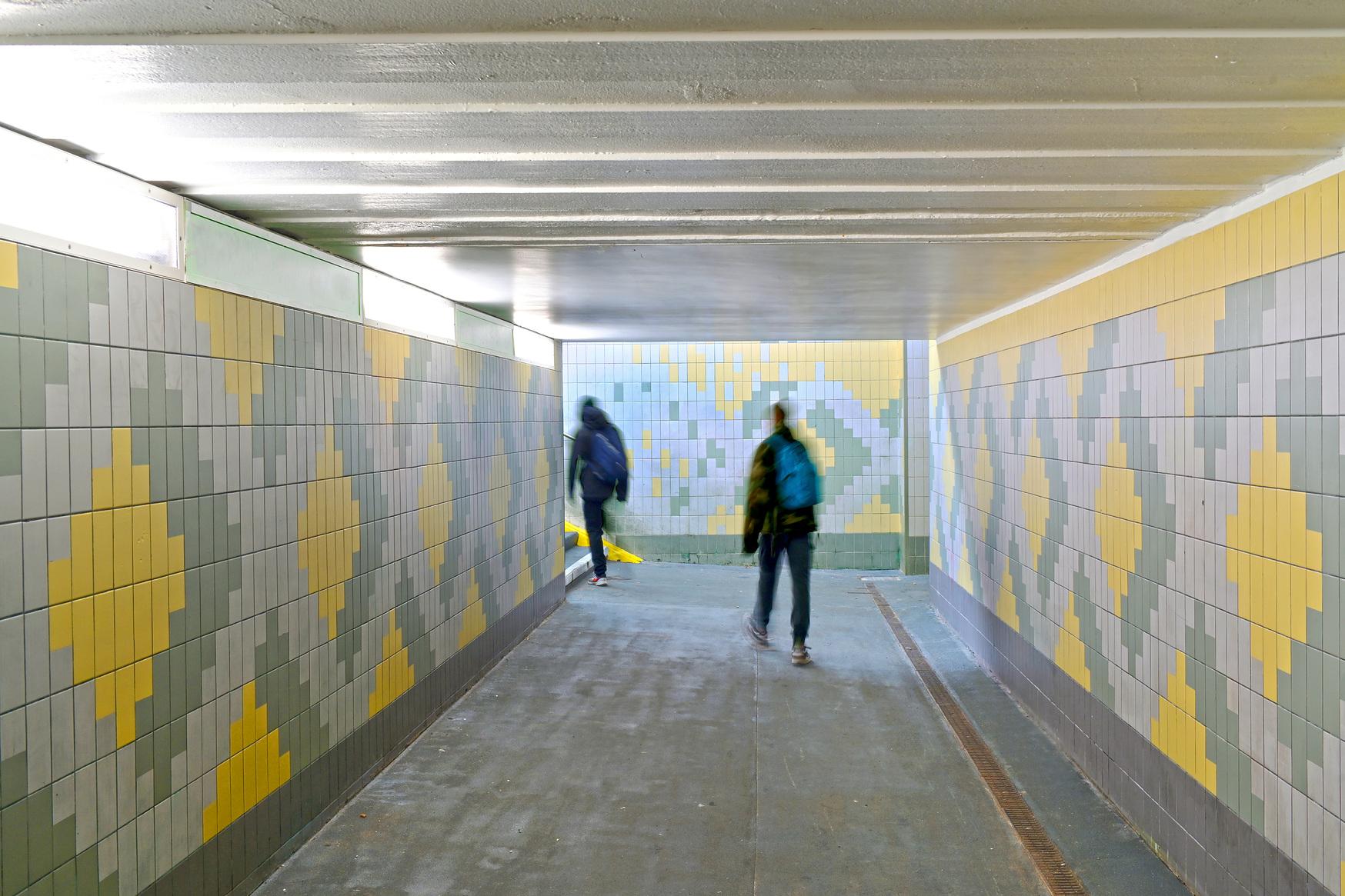 Zwei Personen laufen durch die neue Unterführung des Bahnhof Werder (Havel).